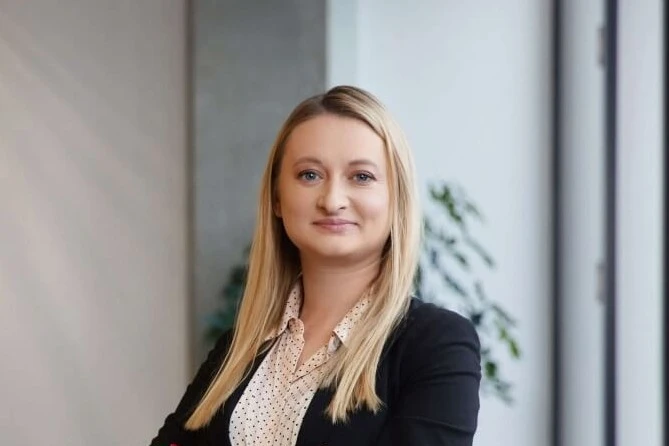 Julija Markeliūnė šypsosi biure su rausva palaidine