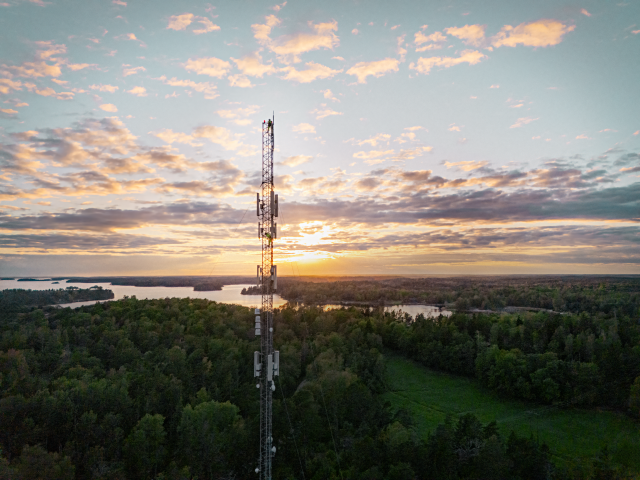 Vaizdas iš aukštai vakare. 5G ryšio antena, dangus ir ežerai apsšviesti besileidžiant saulei