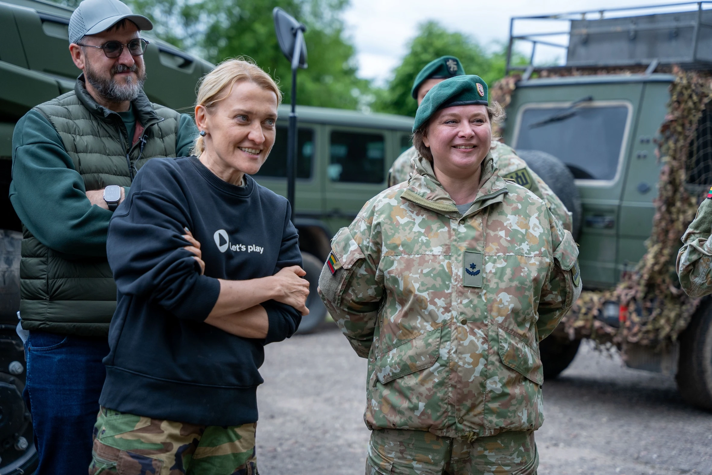 Giedrė Kaminskaitė-Salters kartu su Lietuvos kariuomenės nariais šypsosi prie karinės technikos