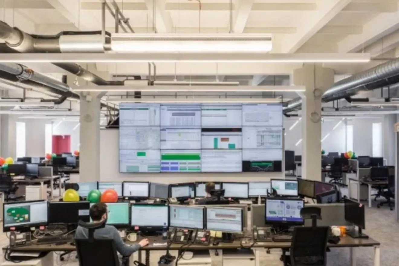 Telia Šiaulių biuro vidus, siena su dideliais monitoriais, dirba monitoringo komanda