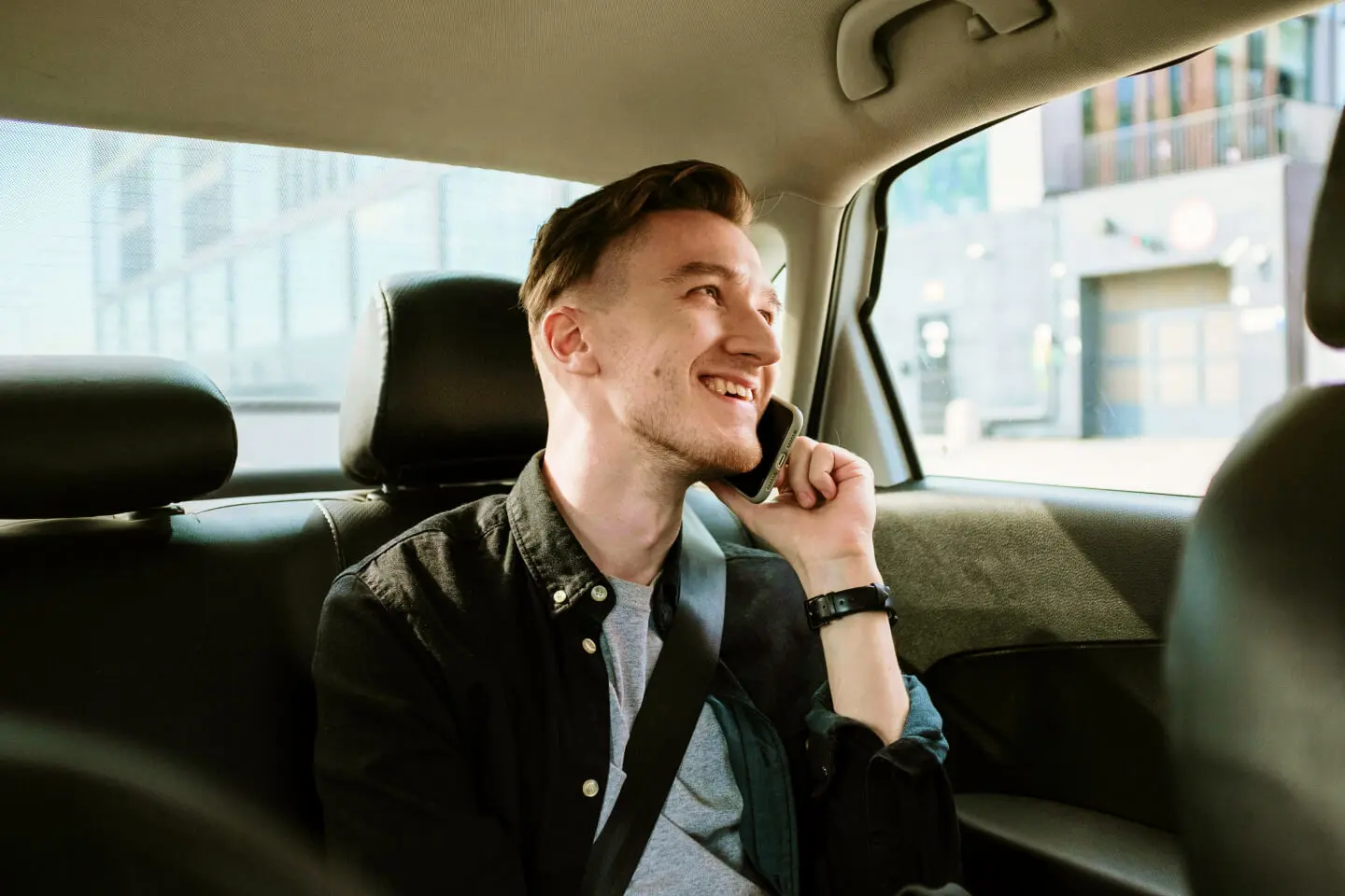 Vaikinas kalba mobiliuoju telefonu automobilyje.