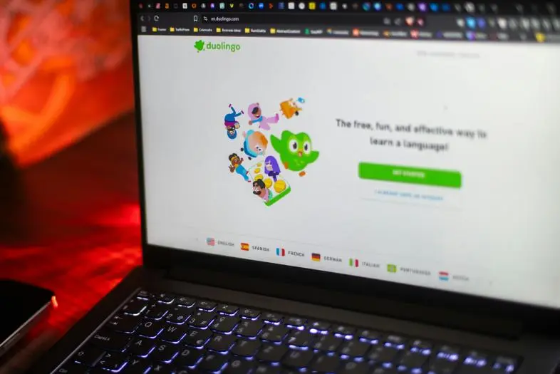 Kompiuterio ekrane rodoma „Duolingo“ pradžios svetainė su kalbų pasirinkimais ir registracijos mygtuku.