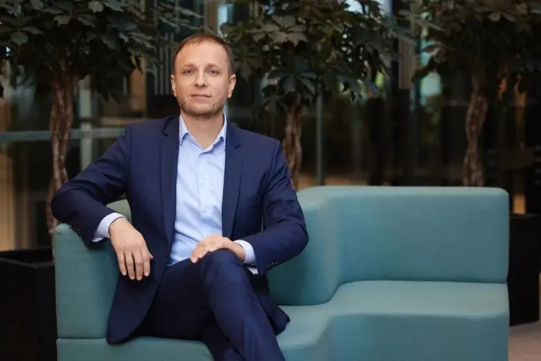 Telia Verslo produktų vadovas Giedrius Jasonas sėdi ant sofos