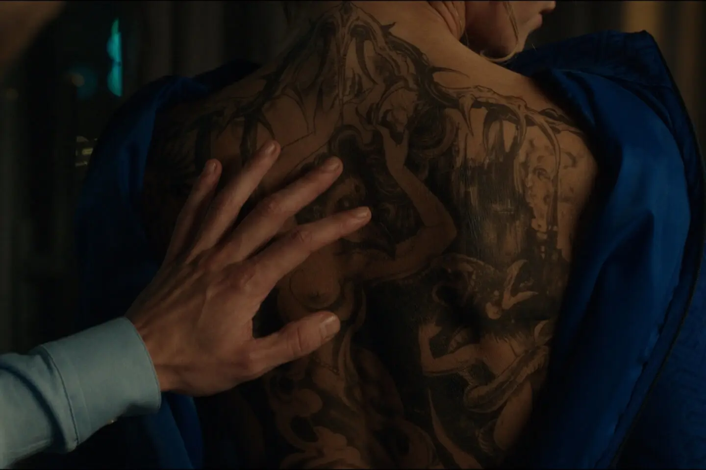 Kadras iš serialo - mergina su tatuiruote ant nugaros